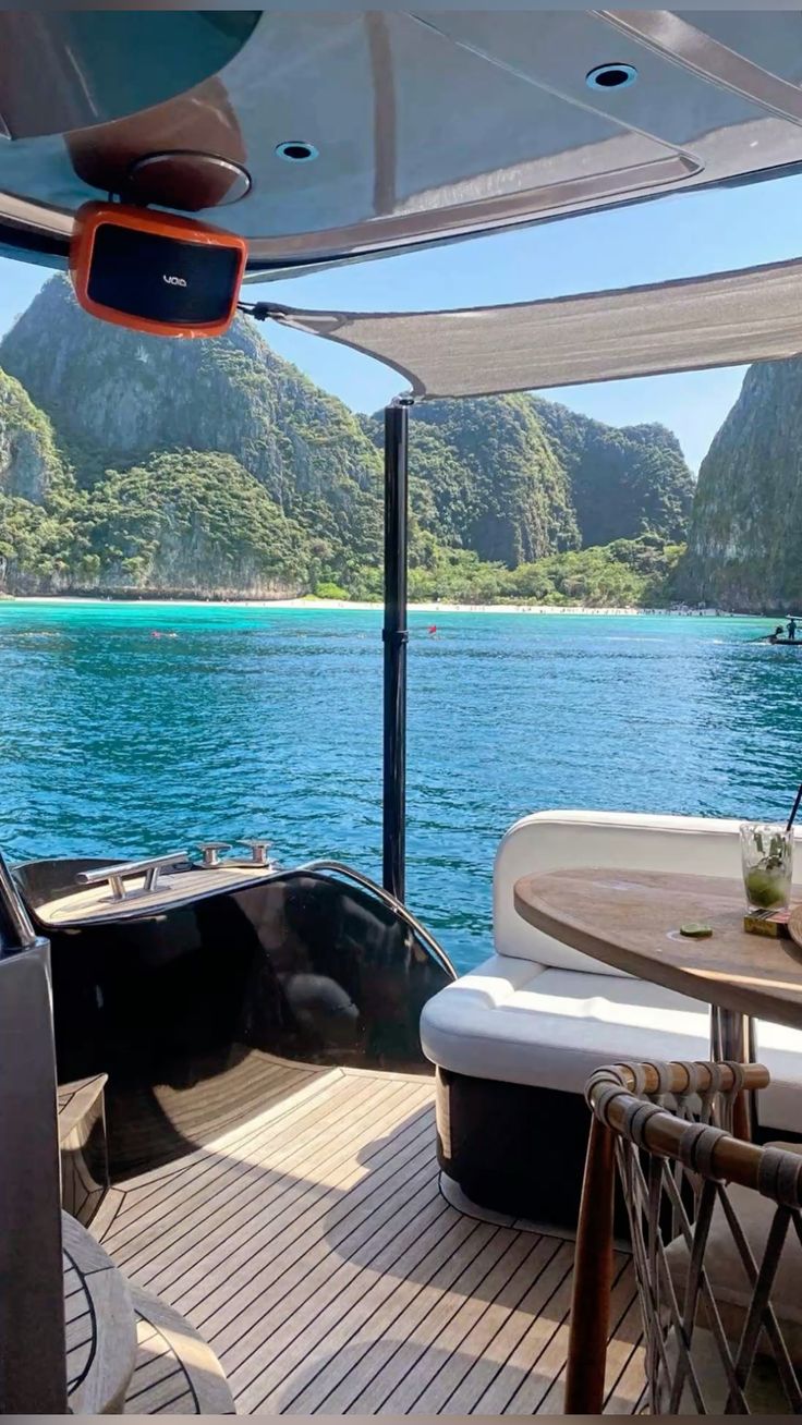 Yacht deck with seating overlooking a turquoise bay and limestone cliffs in Thailand