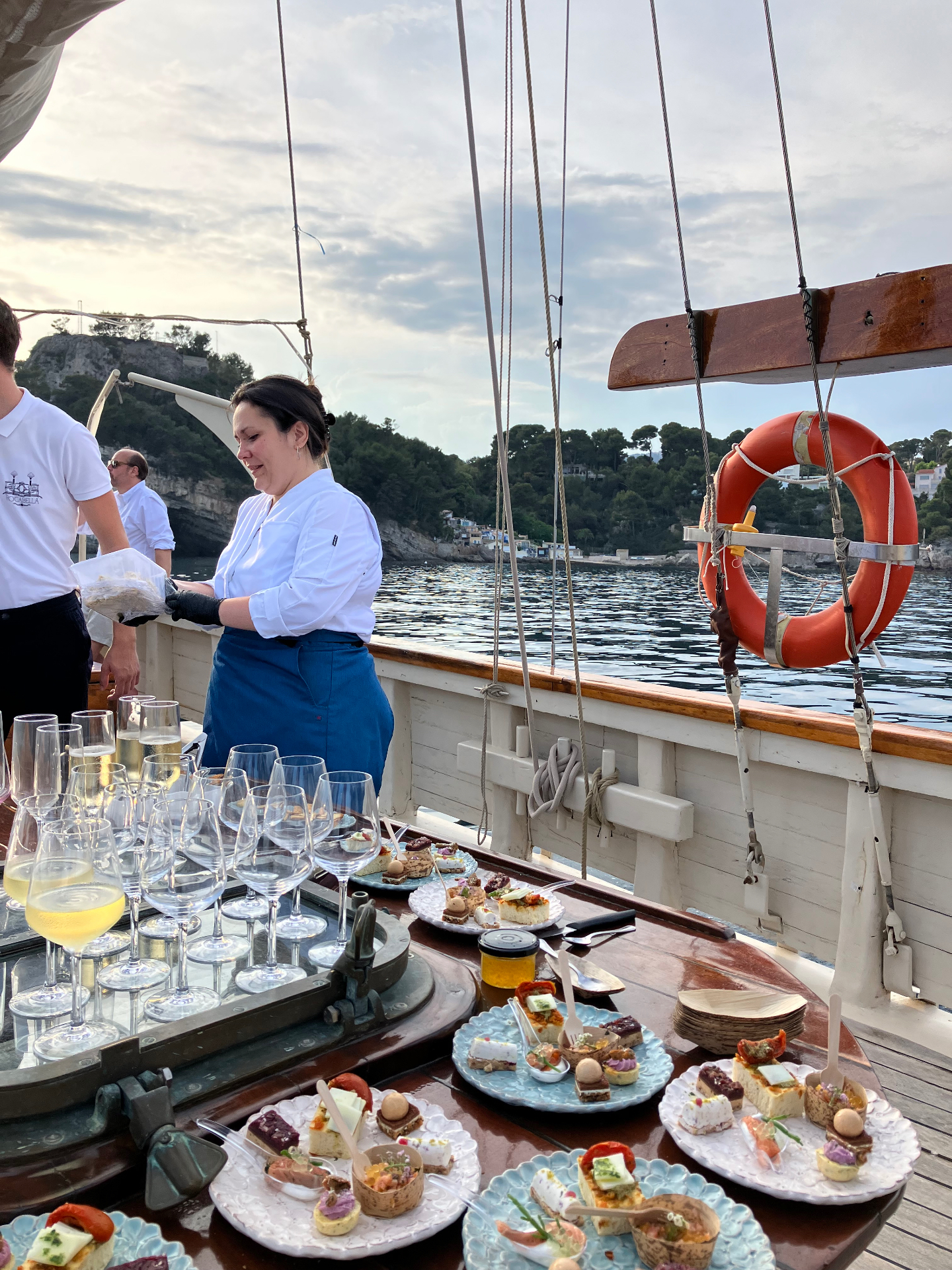 Catering service on a classic sailing yacht off the Riviera, champagne and canapés arranged on deck