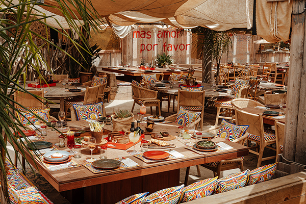 Private beach club restaurant in Ramatuelle with wooden tables, woven canopies and Mediterranean cushions